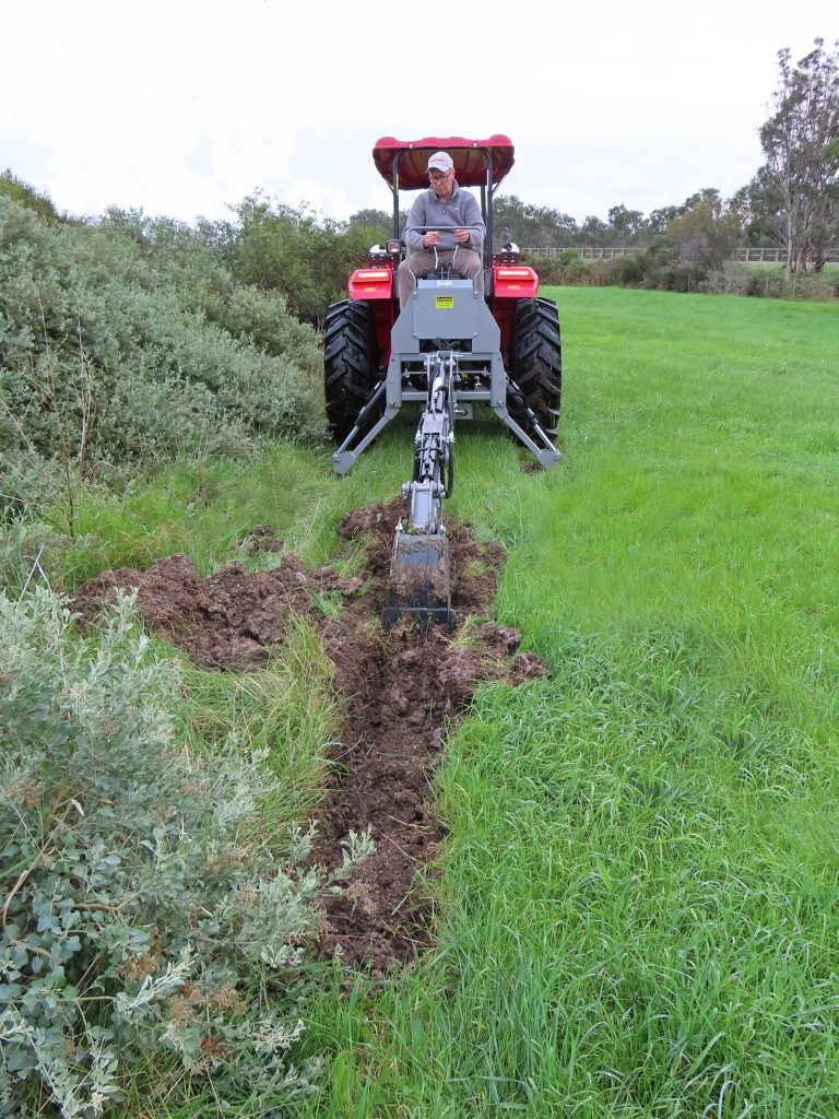 Digging a trench with the AGMAX M195 backhoe.